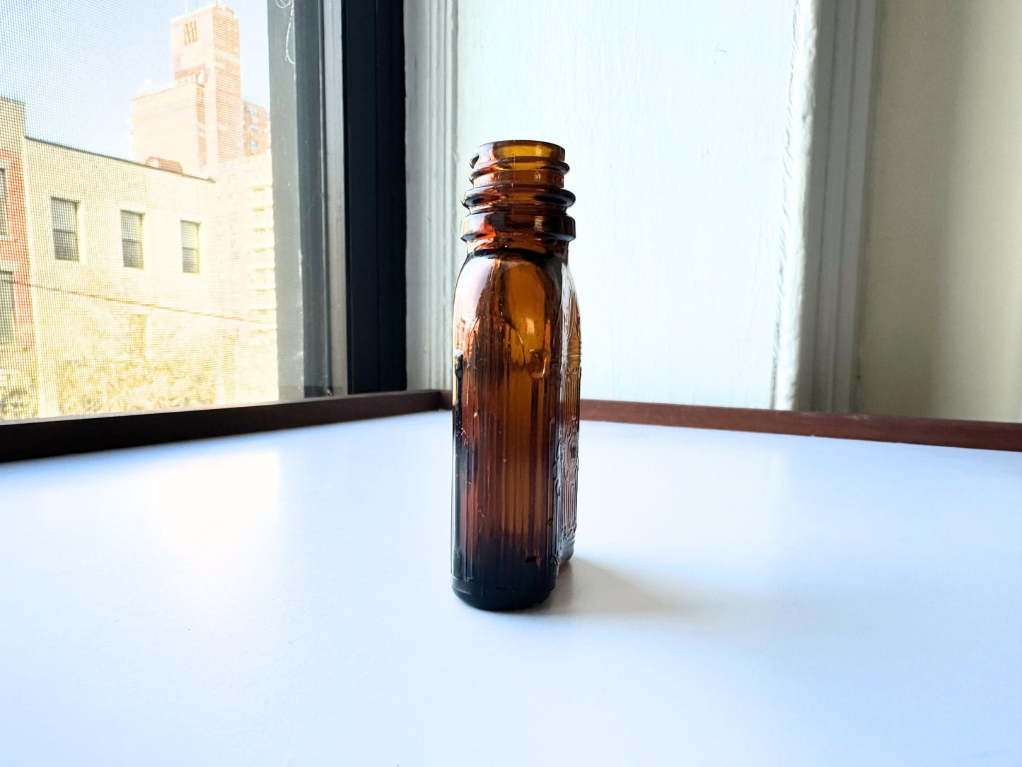 Vintage Hiram Walker small amber bottle with embossed "W" logo on bottom. Perfect for spirits collectors, bar displays, and vintage amber glass enthusiasts. Good condition warm amber glass bottle with minor nicks showing authentic vintage w