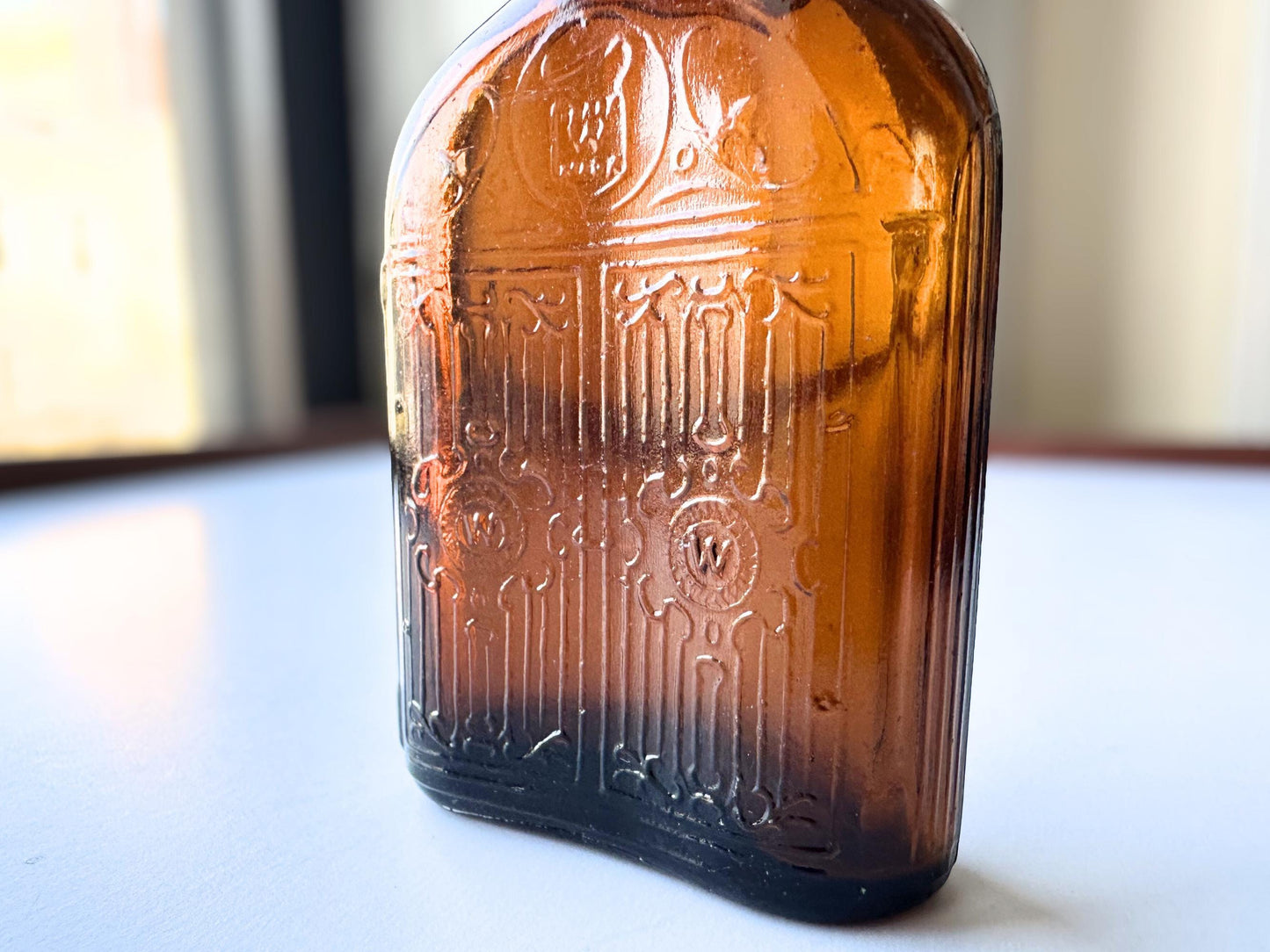 Vintage Hiram Walker small amber bottle with embossed "W" logo on bottom. Perfect for spirits collectors, bar displays, and vintage amber glass enthusiasts. Good condition warm amber glass bottle with minor nicks showing authentic vintage w