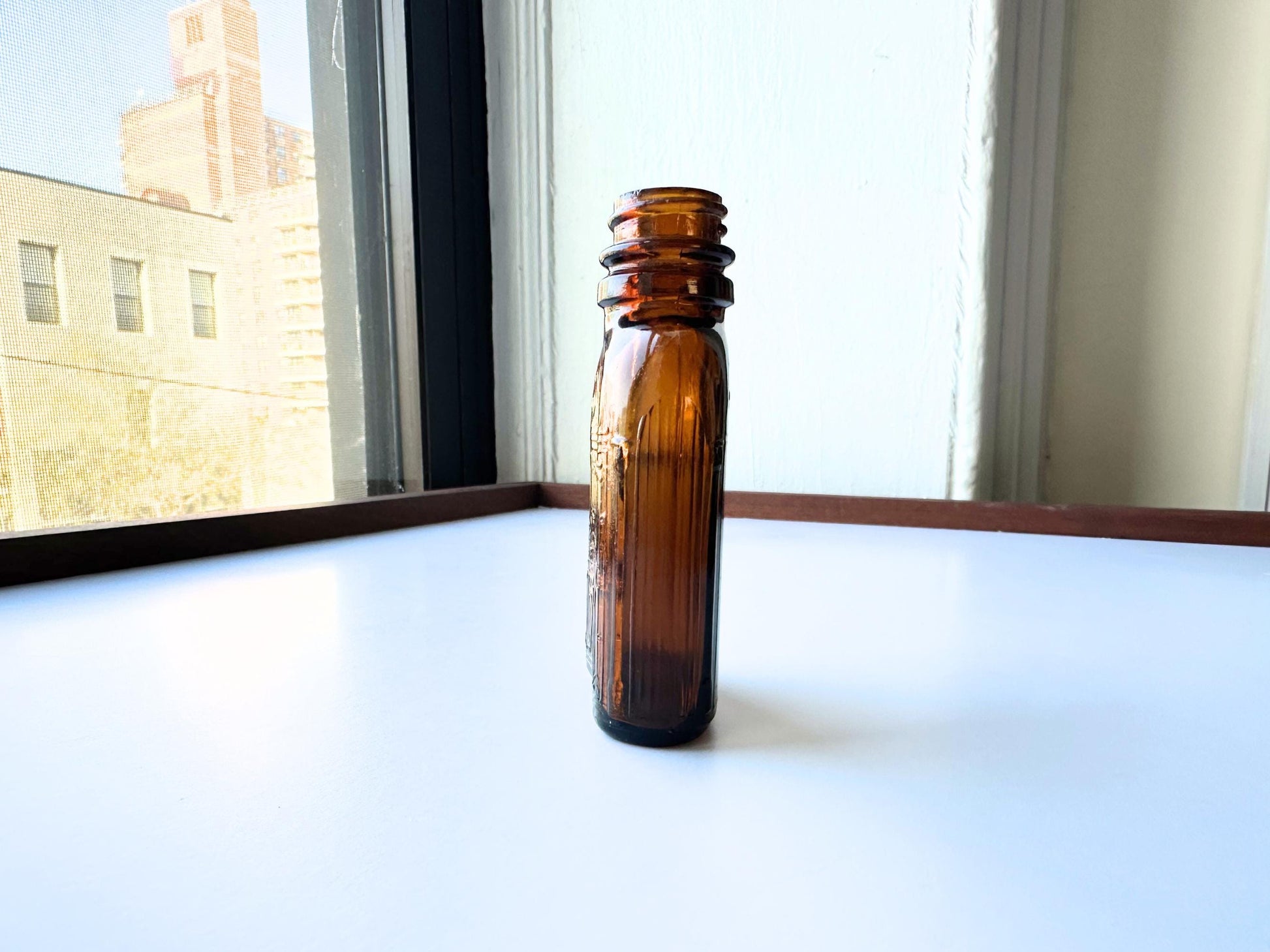 Vintage Hiram Walker small amber bottle with embossed "W" logo on bottom. Perfect for spirits collectors, bar displays, and vintage amber glass enthusiasts. Good condition warm amber glass bottle with minor nicks showing authentic vintage w