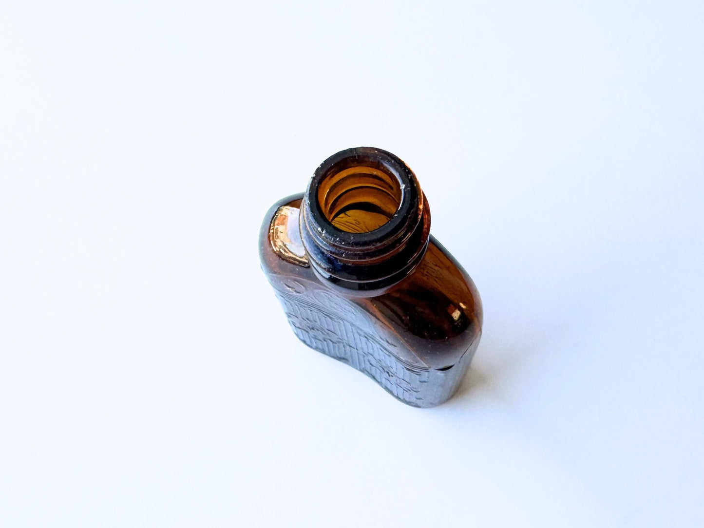 Vintage Hiram Walker small amber bottle with embossed "W" logo on bottom. Perfect for spirits collectors, bar displays, and vintage amber glass enthusiasts. Good condition warm amber glass bottle with minor nicks showing authentic vintage w