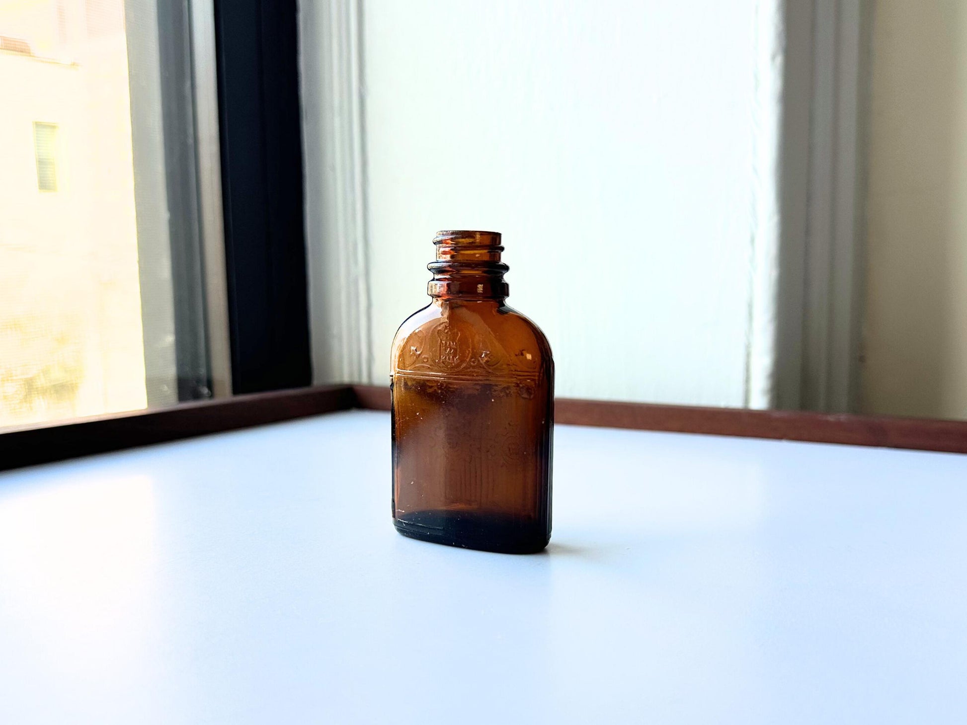Vintage Hiram Walker small amber bottle with embossed "W" logo on bottom. Perfect for spirits collectors, bar displays, and vintage amber glass enthusiasts. Good condition warm amber glass bottle with minor nicks showing authentic vintage w