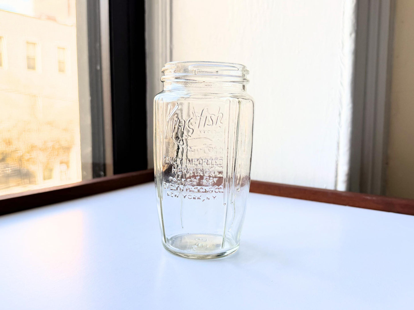 Vintage 1920s-1940s Kingfish Brand clear glass herring jar with bold embossed lettering from Evelyn Packing Company in New York. Perfect for windowsill displays, vintage kitchen collections, and farmhouse or cottagecore decor.