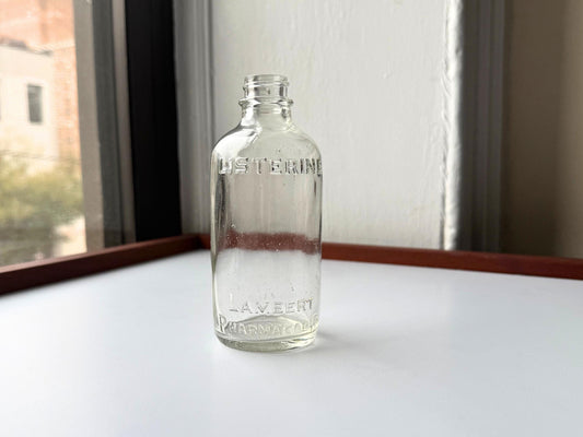 Elegant early 20th-century Listerine bottle from Lambert Pharmacal Co with embossed lettering and textured base perfect for vintage apothecary collectors pharmaceutical history displays bathroom shelf styling.