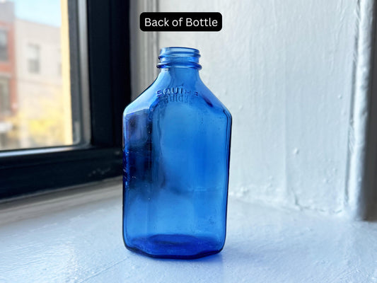 Back of vintage cobalt blue Squibb glass bottle showcasing its embossed lettering and unique octagonal shape – Brooklyn Sea Glass