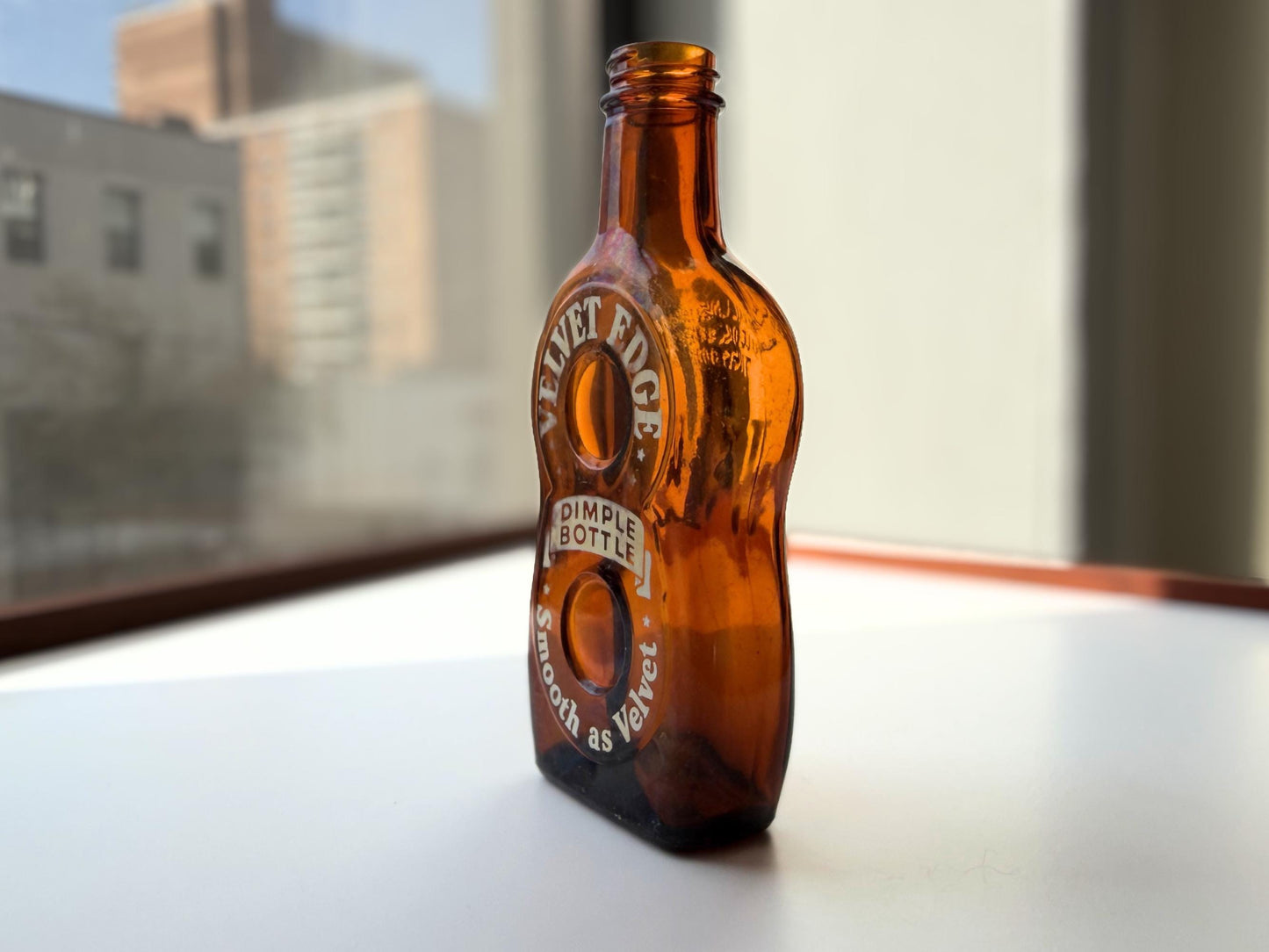 Vintage Velvet Edge amber dimple bottle 7 inches tall dated 1952 with figure-8 silhouette and Federal Law embossing - hand-recovered from NYC mid-century dumping grounds