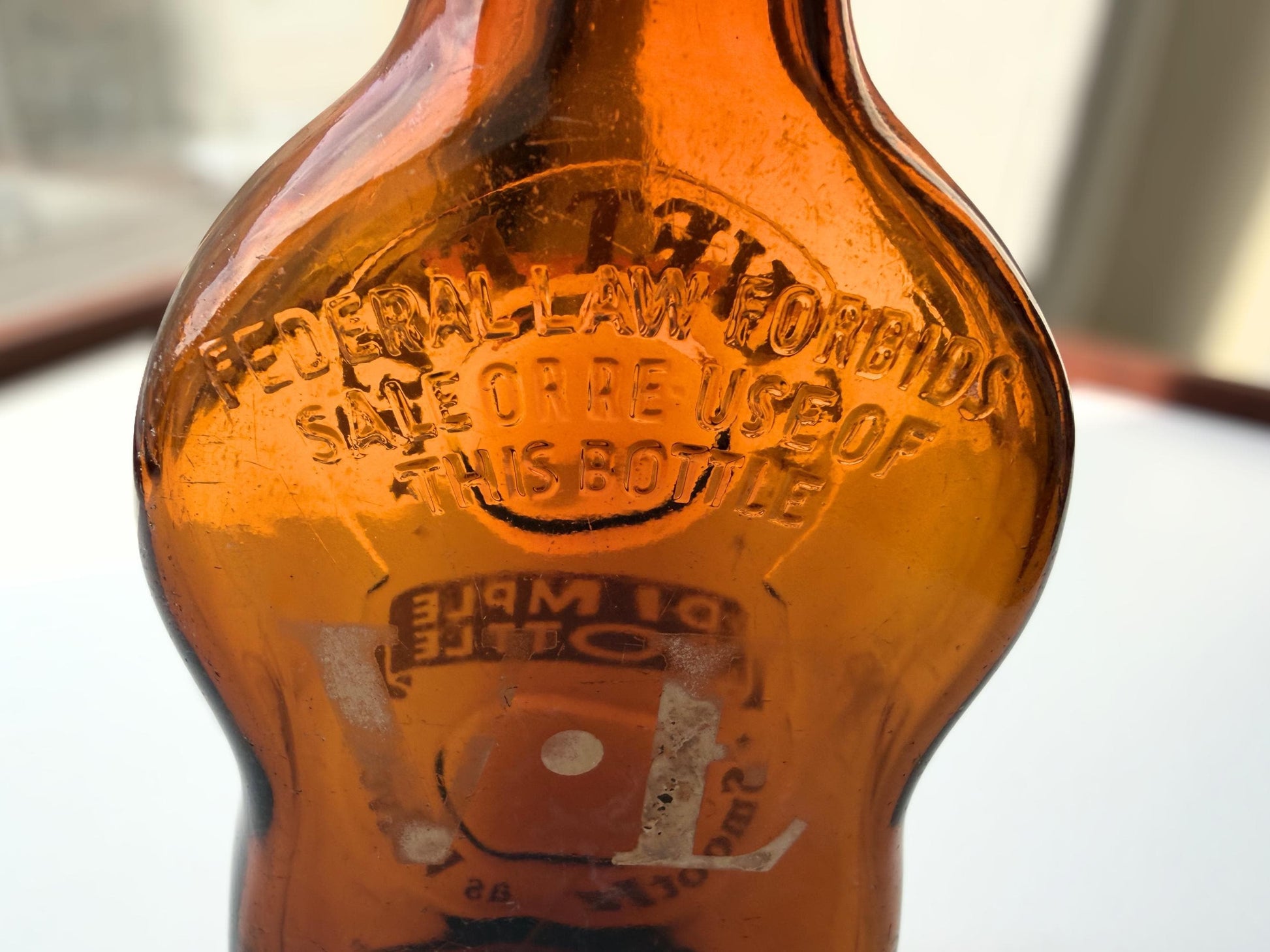 Vintage Velvet Edge amber dimple bottle 7 inches tall dated 1952 with figure-8 silhouette and Federal Law embossing - hand-recovered from NYC mid-century dumping grounds