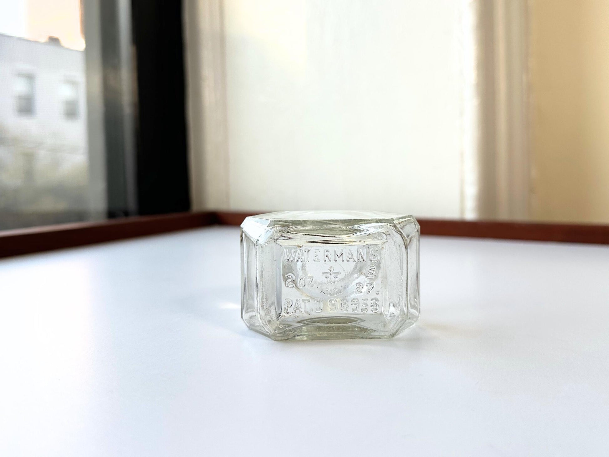 Vintage Waterman's 2oz ink bottle with hexagonal shape and patent marking. Perfect for vintage stationery collectors, office displays, and writing enthusiasts.
