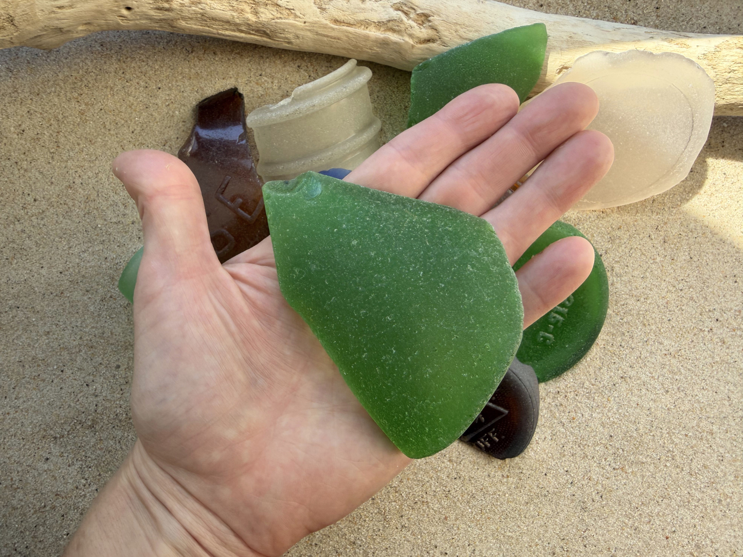 Hand holding XL green sea glass to show scale, extra large 3-4 inch authentic Brooklyn beach glass piece