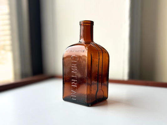 Cointreau 1951 amber glass bottle full front view, square shape, NYC beach recovery