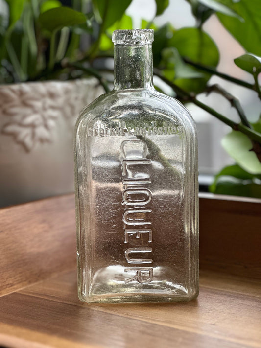 Cointreau clear glass bottle side view showing square tapered neck design