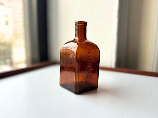 Cointreau amber bottle side view showing square glass form