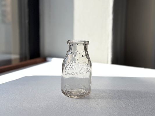 Elmhurst Cream Co. milk bottle with dimension overlay showing 4.75 inches tall by 2.5 inch diameter clear glass