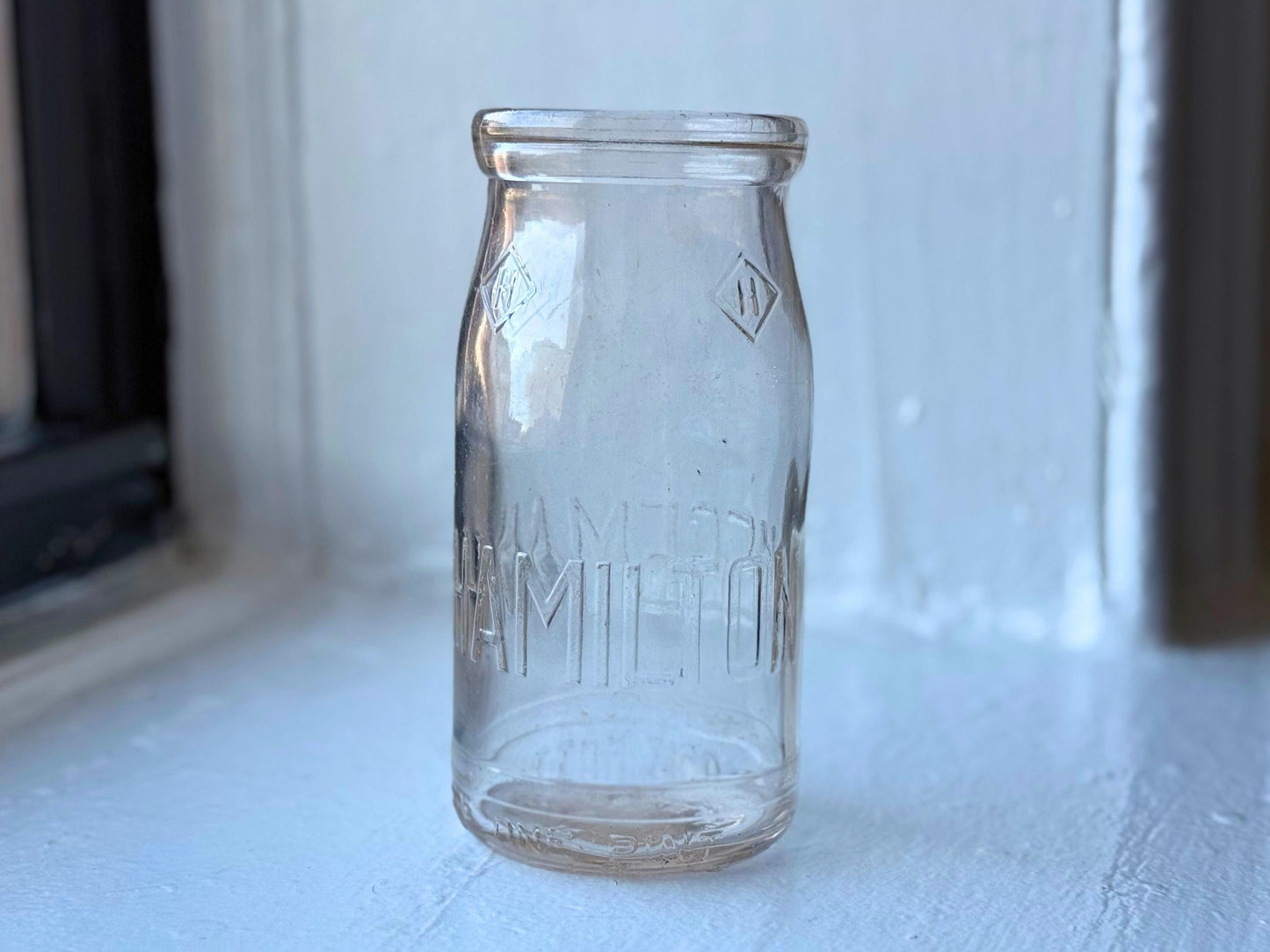 Hegeman Hamilton milk bottle back view showing clear glass and bold embossed branding, 1951 Queens NY