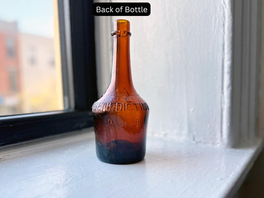 Back view of the vintage B&B Benedictine bottle, highlighting additional embossed details and the amber glass finish.