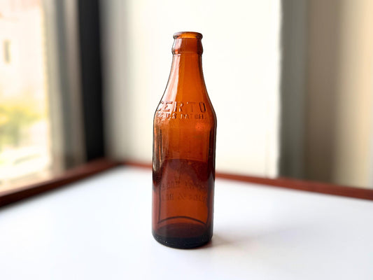 Vintage 1930s-1940s Certo fruit pectin bottle in rich amber glass, rescued from NYC beach. Features embossed "CERTO REG. U.S. PAT. OFF" lettering and unique upside-down "Pour to Here" measurement guide. Depression-era American kitchen collectible measuring 7.25 inches tall by 2.25 inches diameter. Base marked "Made in USA." Authentic dug bottle with age-appropriate patina from Brooklyn Sea Glass.