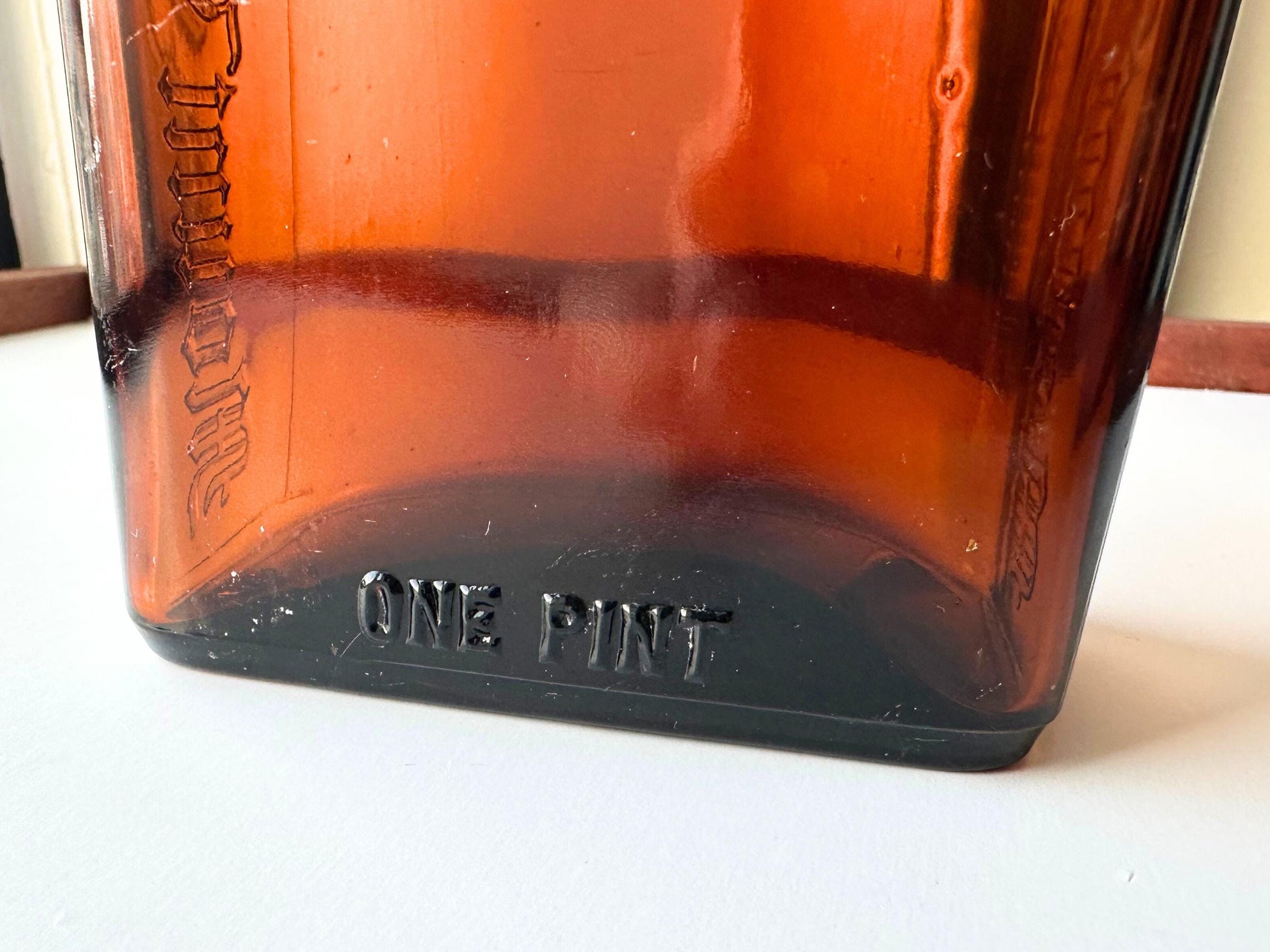 Vintage Mount Vernon straight whiskey bottle, 8.5 inches tall by 3.5 inches wide, rescued from NYC beaches. Features embossed "MOUNT VERNON" lettering and "FEDERAL LAW FORBIDS SALE OR REUSE OF THIS BOTTLE" text authentic to mid-century American spirits bottles. Base marked "ONE PINT" for capacity. Perfect for farmhouse decor, vintage bar cart styling, cottagecore displays, or as unique bud vase. Authentic dug bottle with age-appropriate patina from Brooklyn Sea Glass.