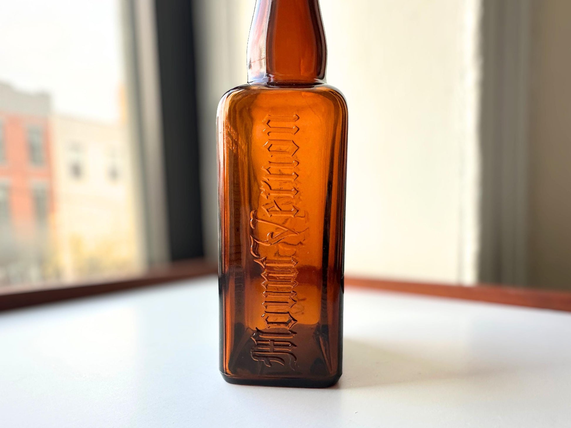 Vintage Mount Vernon straight whiskey bottle, 8.5 inches tall by 3.5 inches wide, rescued from NYC beaches. Features embossed "MOUNT VERNON" lettering and "FEDERAL LAW FORBIDS SALE OR REUSE OF THIS BOTTLE" text authentic to mid-century American spirits bottles. Base marked "ONE PINT" for capacity. Perfect for farmhouse decor, vintage bar cart styling, cottagecore displays, or as unique bud vase. Authentic dug bottle with age-appropriate patina from Brooklyn Sea Glass.