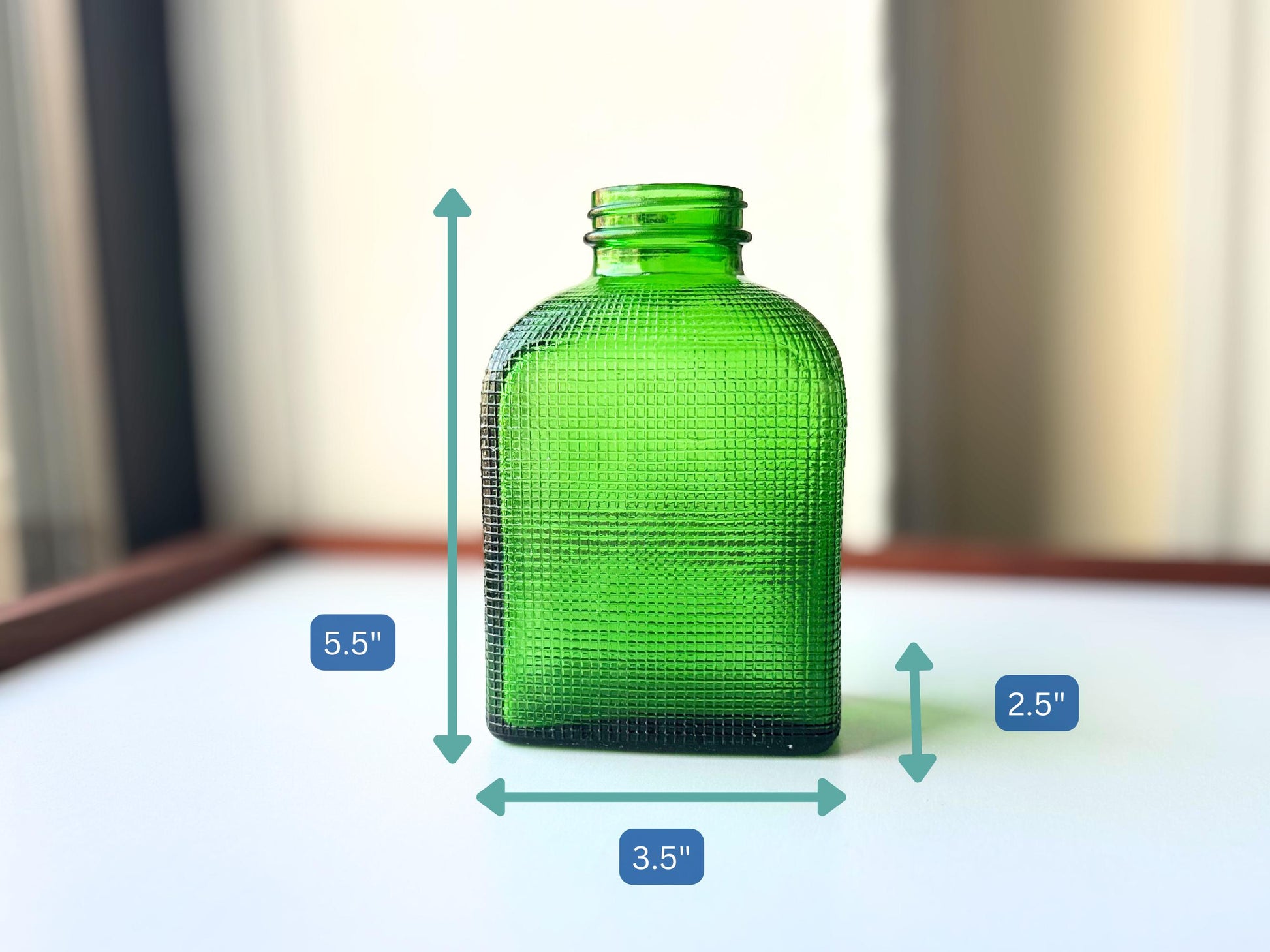 Stunning vintage emerald green glass bottle with distinctive waffle-grid texture throughout perfect for mid-century collectors farmhouse decor. Authentic 1950 bottle features tactile raised square pattern squared flask shape catches light beautifully. Rich emerald green three-dimensional textured surface. Ideal for windowsill displays vintage bottle collections retro kitchen shelves small bud vases statement pieces open shelving MCM cottagecore maximalist vintage interiors sustainable.