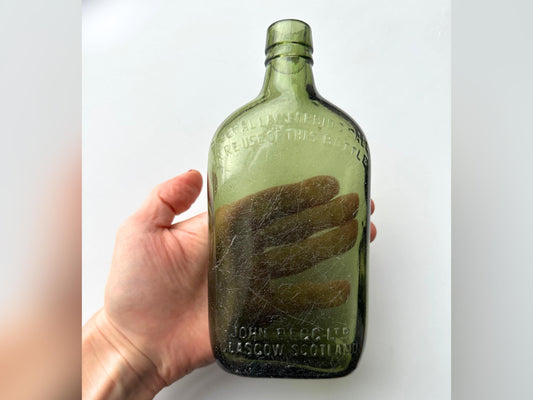 John Begg Scotch bottle held in hand showing scale, 7.5 inch green glass 1930s NYC recovery