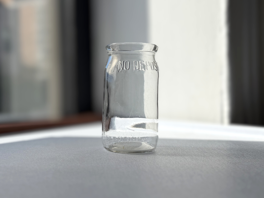 No Deposit 1954 pint milk bottle angled left view, clear glass with embossed text, exceptional condition