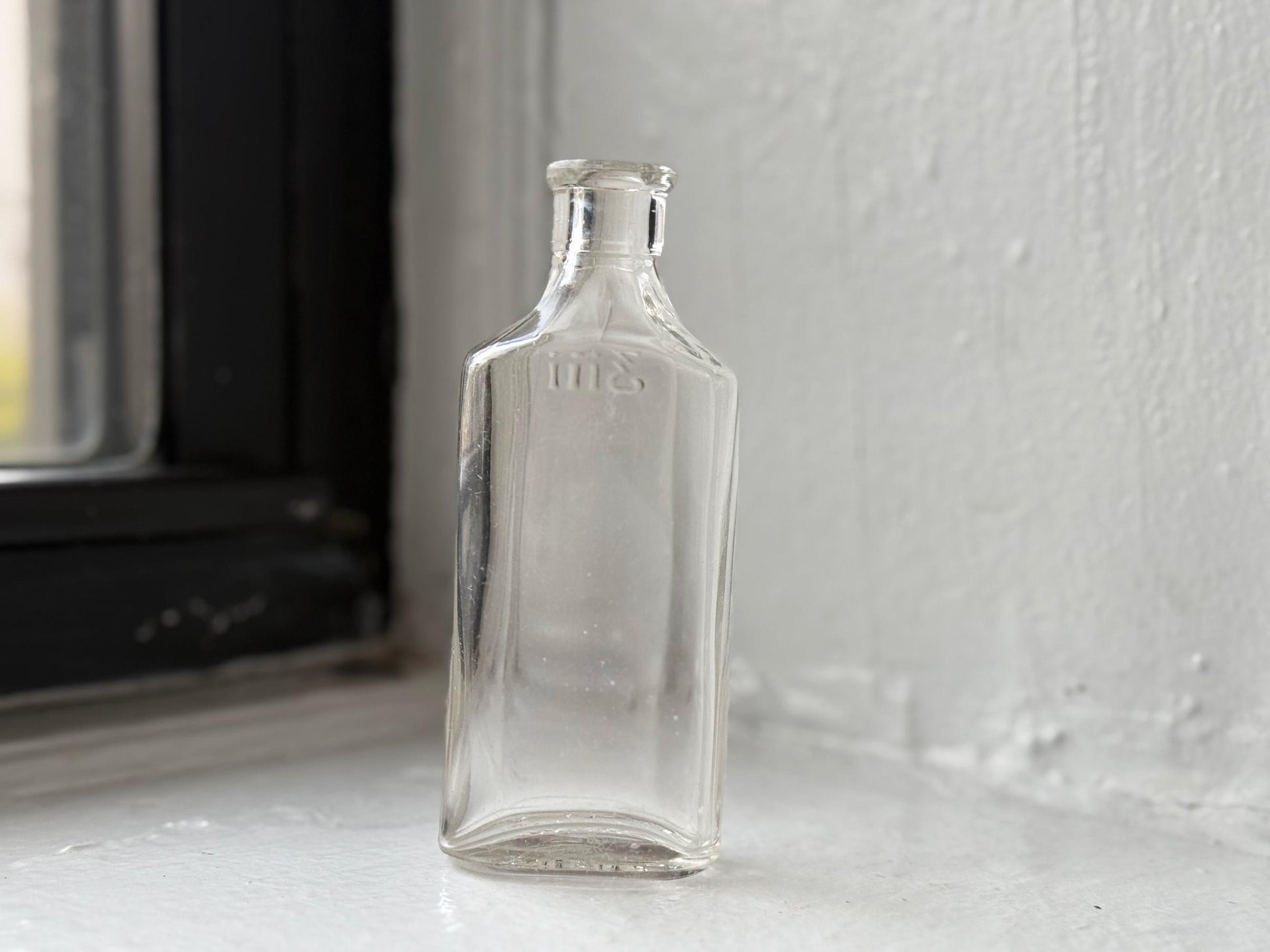 Owens Glass medicine bottle back view showing rectangular form and vintage wear, clear glass NYC recovery