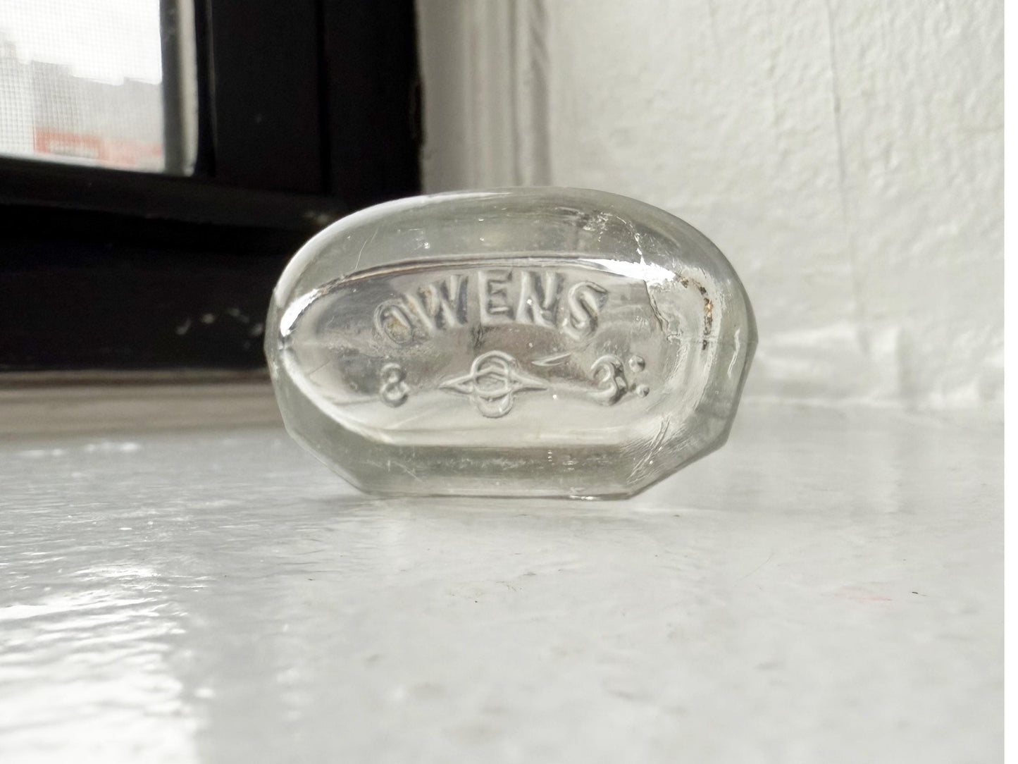 Owens Glass medicine bottle base showing circle-O maker mark, reliable dating reference for collectors