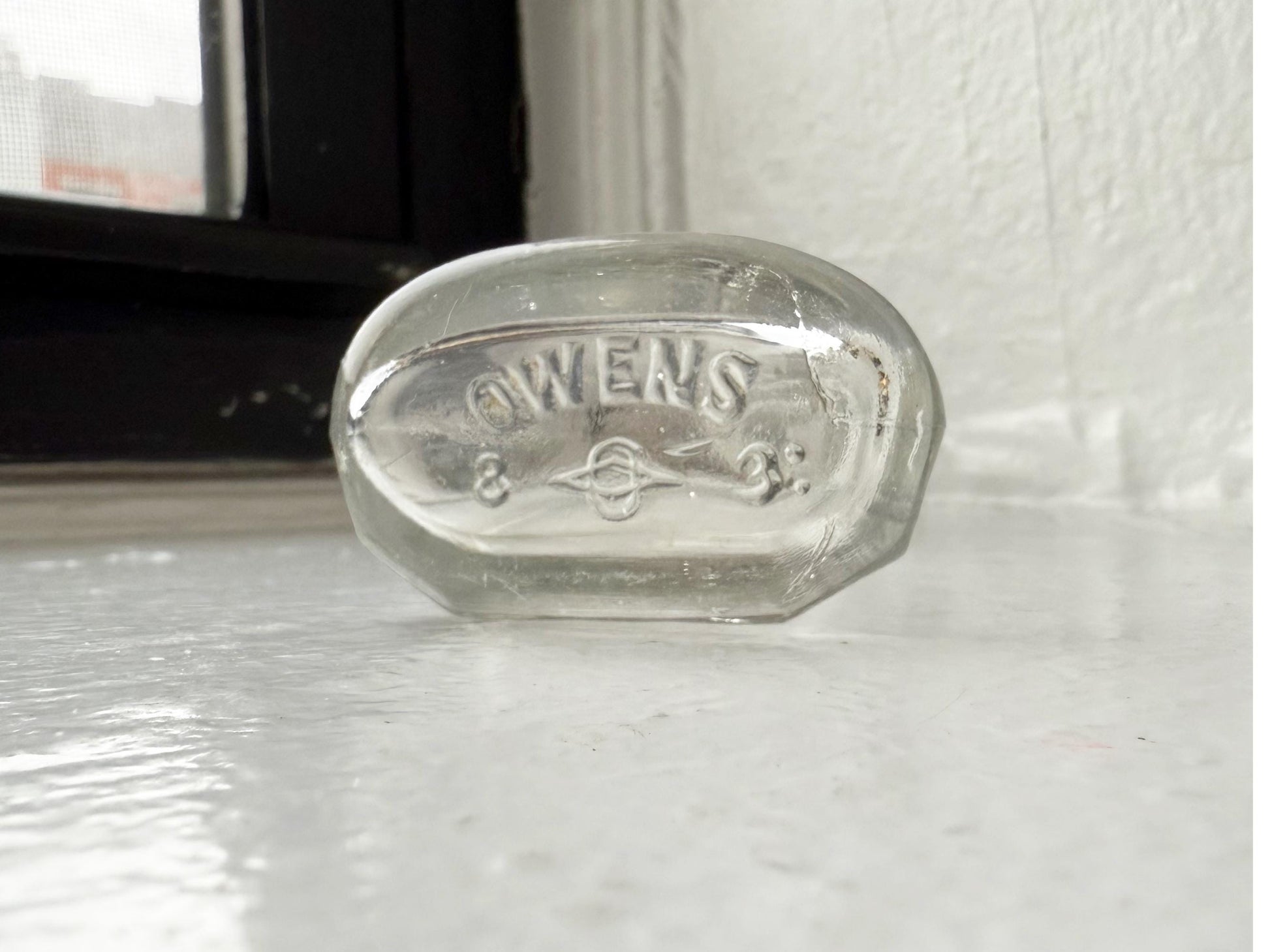Owens Glass medicine bottle base showing circle-O maker mark, reliable dating reference for collectors