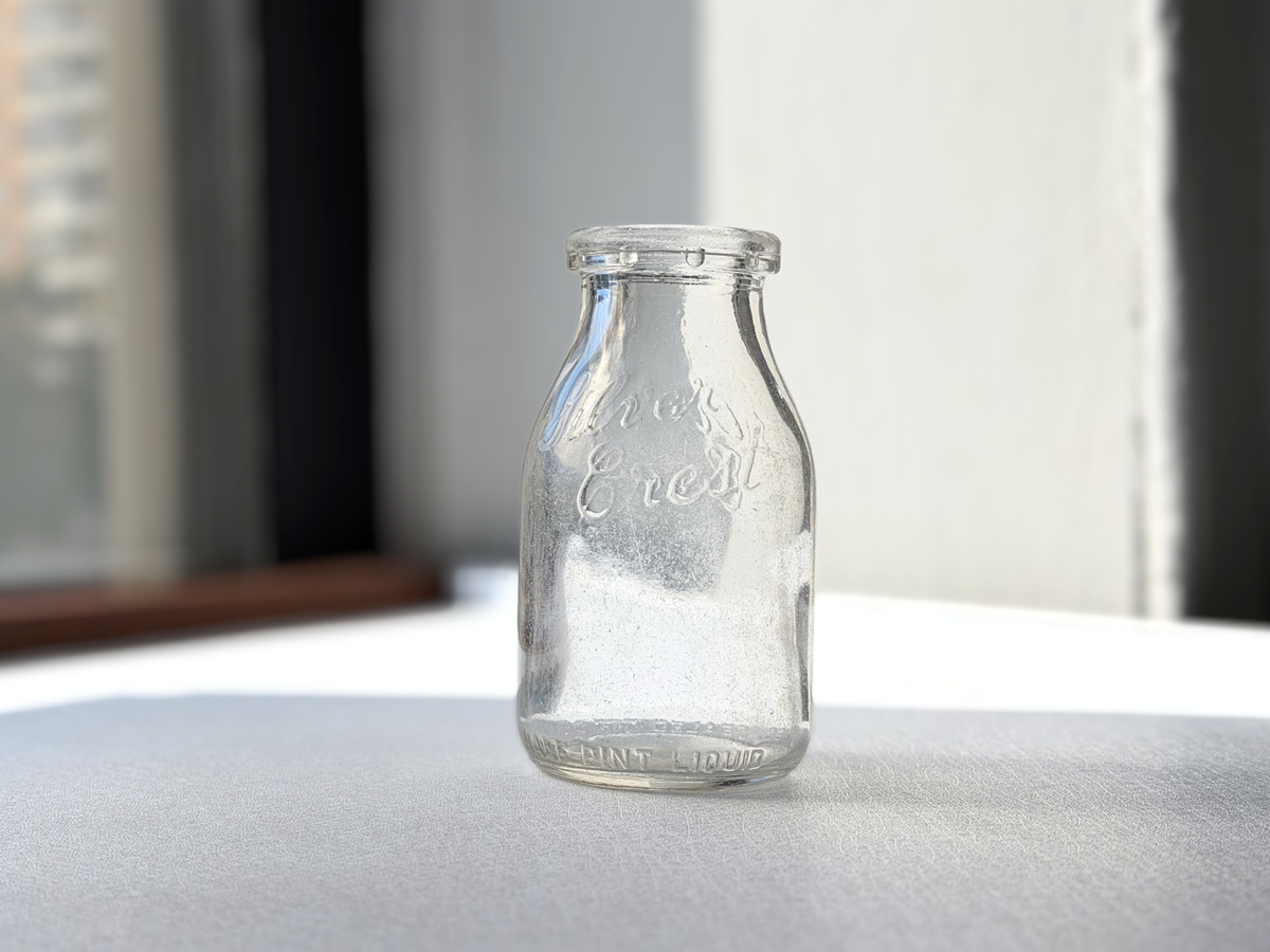 Close-up of Silver Crest Dairy embossed lettering on milk bottle neck
