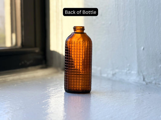 Vintage amber waffle grid bottle angled view showing textured grid pattern, 1940s–50s MCM glass