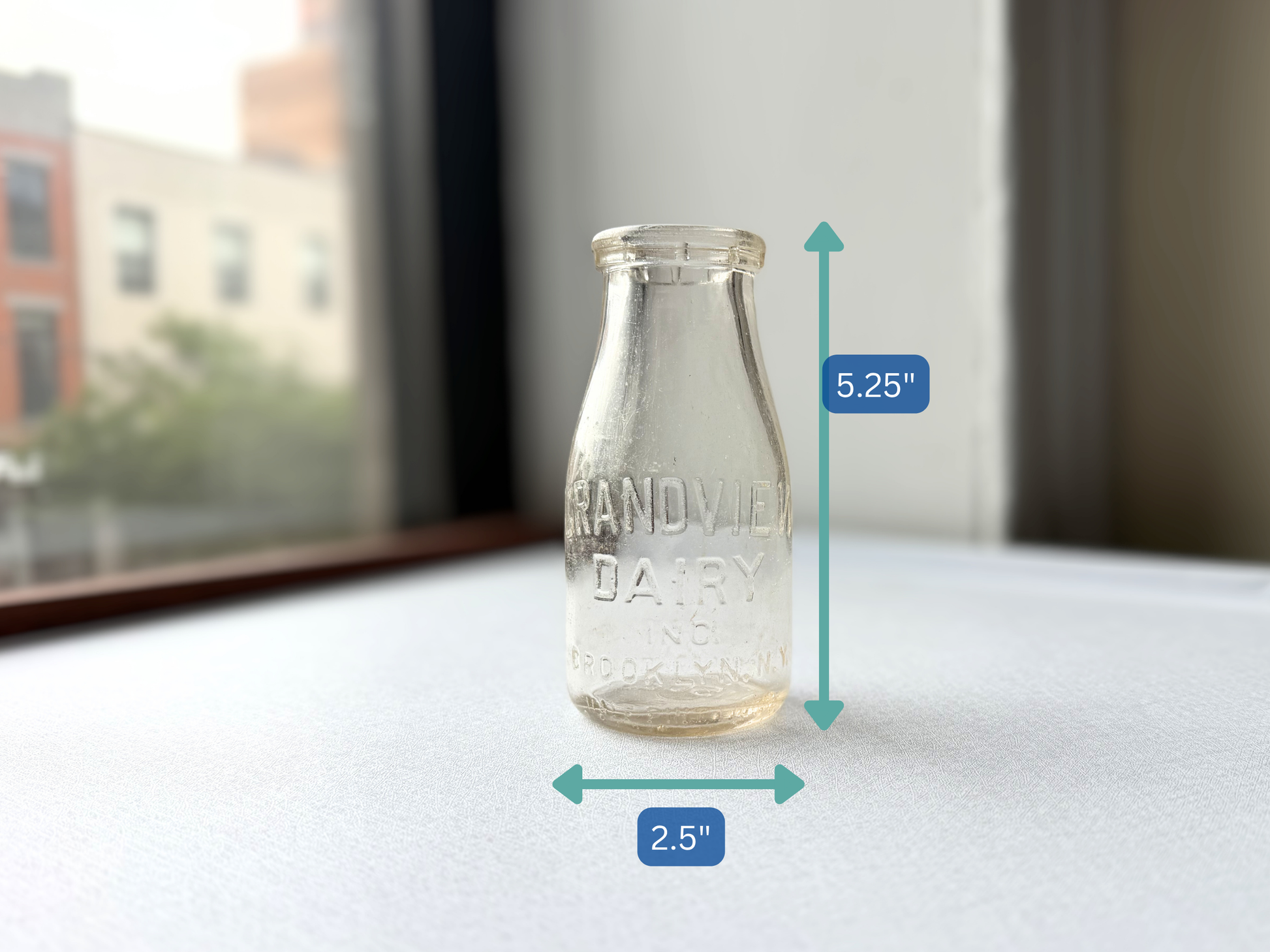 Vintage Grandview Dairy milk bottle shown with measurement markers indicating a height of 5.25 inches and width of 2.5 inches, illustrating its small, tidy scale ideal for a bud vase.