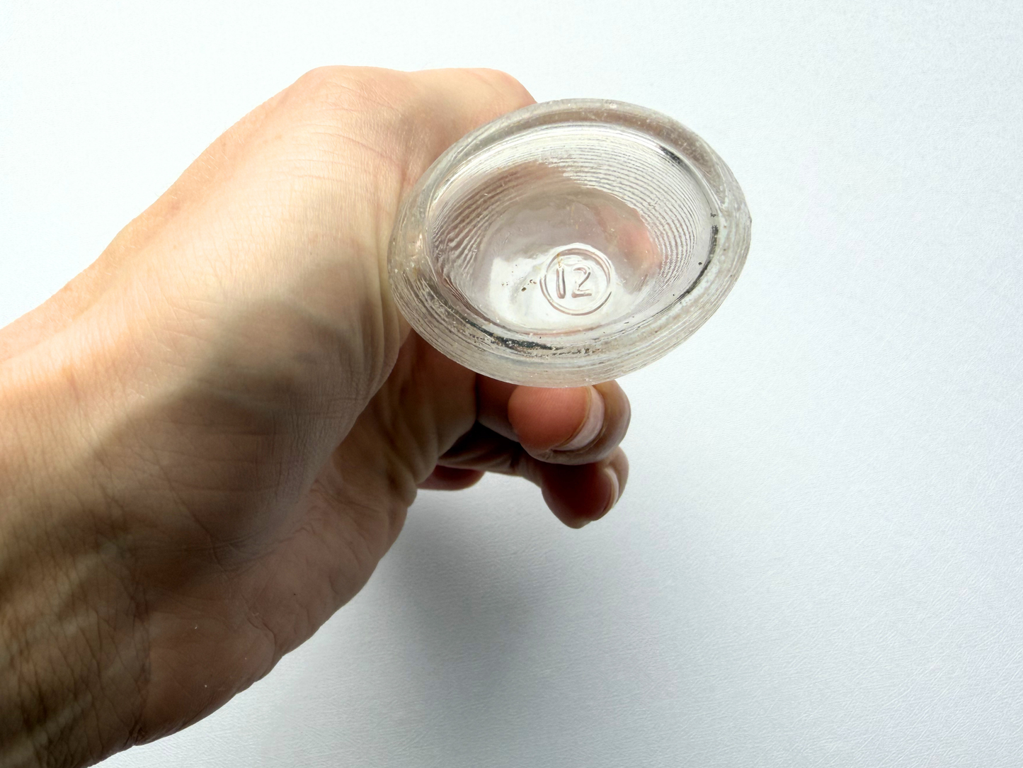 View into the neck opening of a small vintage ribbed glass halo bottle, showing the clear glass interior and confirming it is empty and intended for decorative use only.