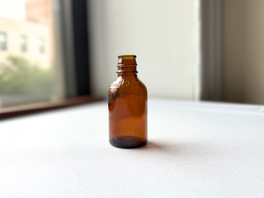 Vintage amber glass Lysol bottle by L&F Products Corp, shown at a three-quarter angle highlighting its rich amber tone and compact apothecary bottle shape.