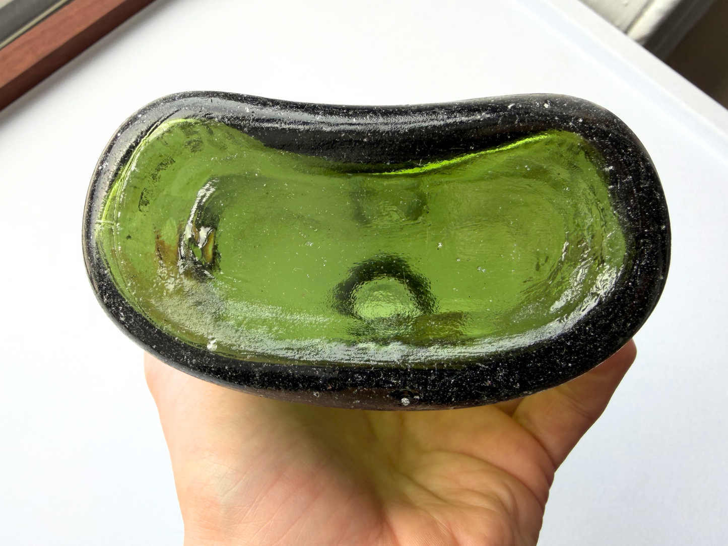 View into the neck opening of a vintage green glass Sanderson bottle, showing the interior glass texture and confirming the bottle is empty and intended for decorative use only.
